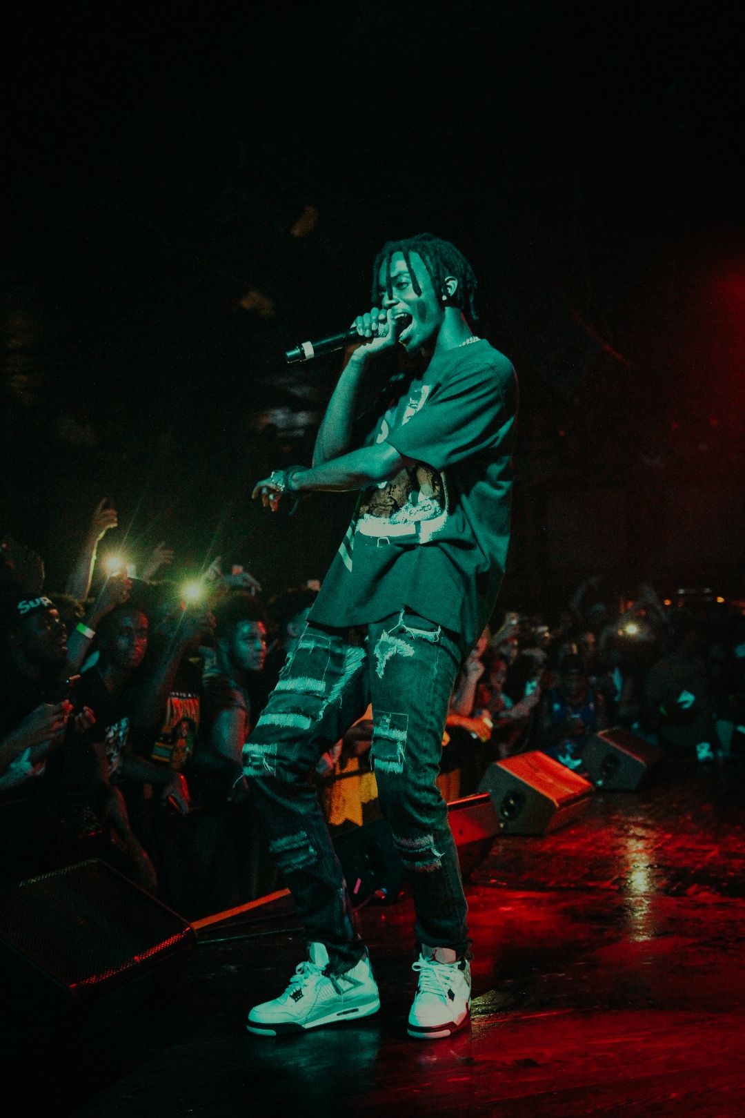 J. Cole performing in white Jordans with green wash