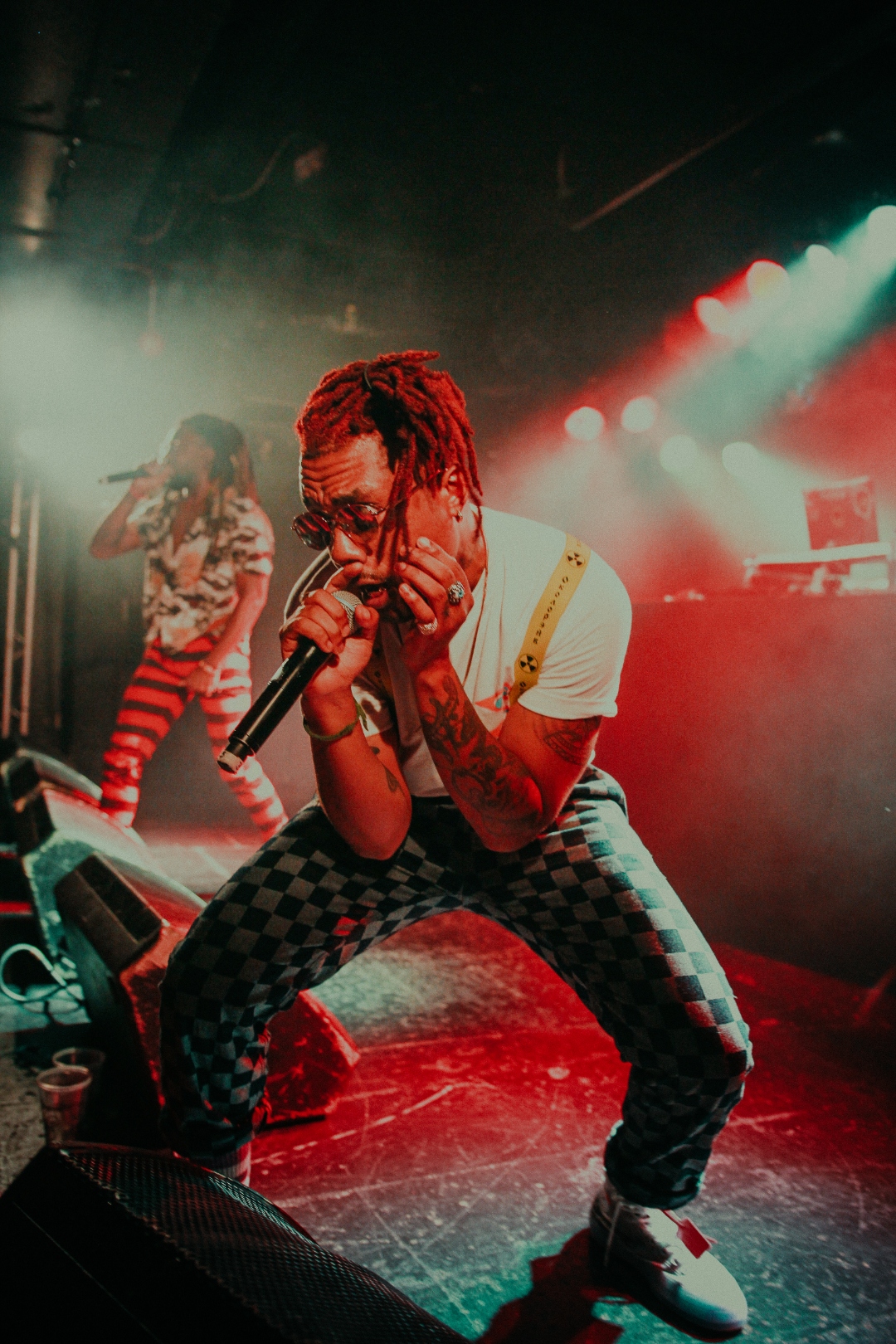 EarthGang performing in red and green haze